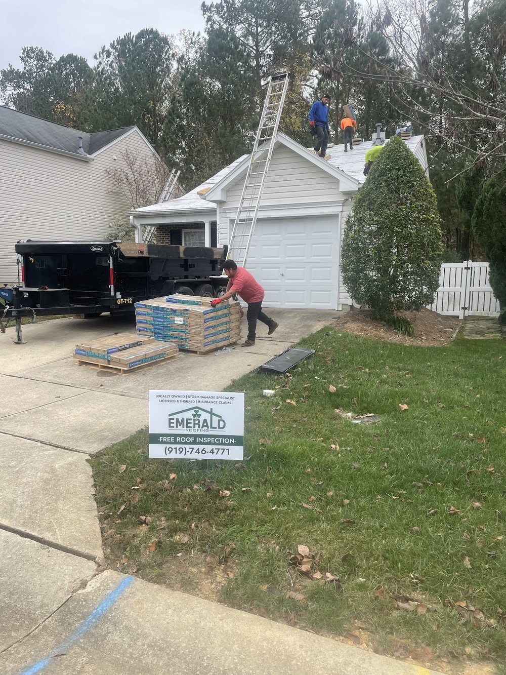 An Emerald Roofing crew member installing architectural shingles, seen from above