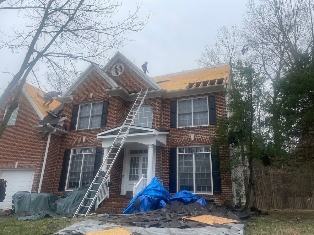 Roof Replacement by Emerald Roofing using Tear off in progress on a brick colonial