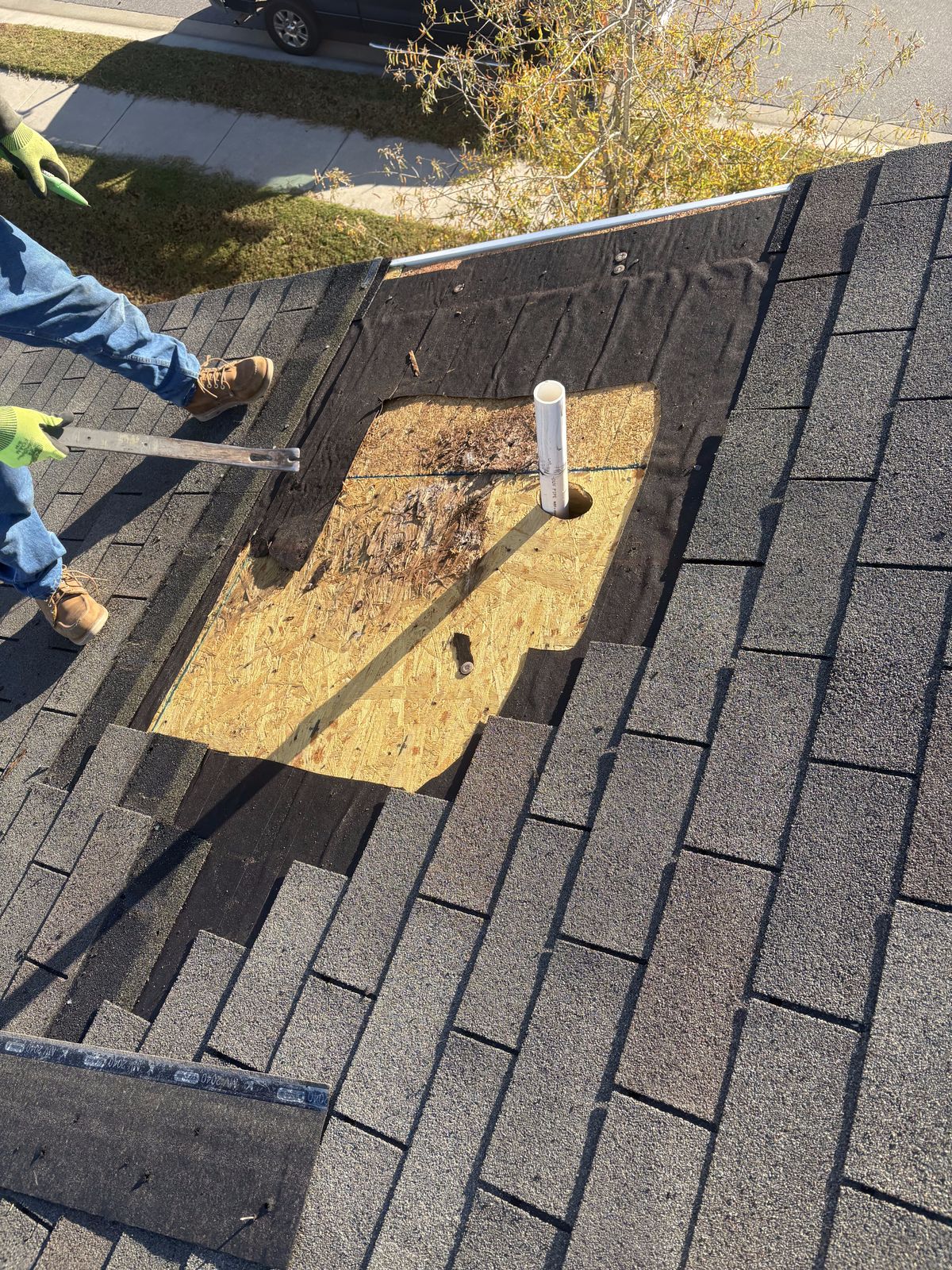 Roof Repair by Emerald Roofing using Shingles opened up around a pipe penetration, showing deteriorated decking beneath